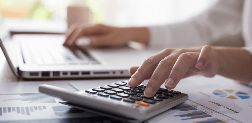 Management Accountant - hands of someone typing on a laptop and calculator